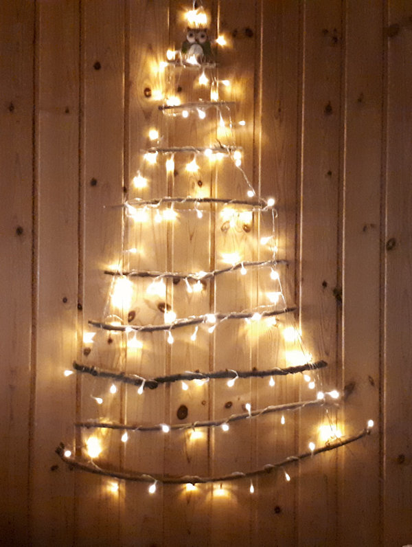 Weihnachtliche Wanddekoration aus Zweigen zum Dekorieren in Form eines Weihnachtsbaumes