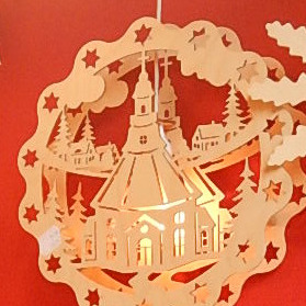Fensterbild mit dem Motiv Seiffner Kirche und kleinen Häusernaus Holz mit Beleuchtung